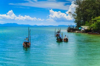 Uzun kuyruk tekne ve mavi gökyüzü ile köy.