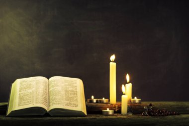 İncil ve eski meşe ahşap bir masa üzerine de mum. Güzel arka plan. Din kavramı