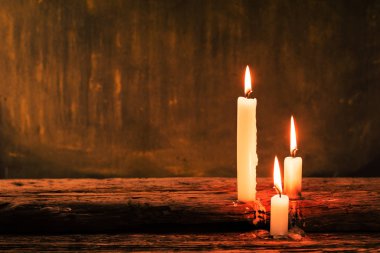 Eski meşe ahşap bir masa üzerinde mum. Güzel altın arka plan. Din kavramı.