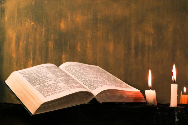 圣经十字架和珠与蜡烛在一个老木燃烧的桌子上 美丽的背景 宗教概念 — 图库照片
