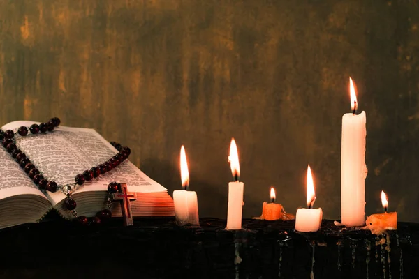 圣经十字架和珠与蜡烛在一个老木燃烧的桌子上 美丽的背景 宗教概念 — 图库照片