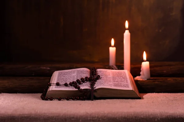 圣经和蜡烛在老橡木桌上 美丽的金色背景 宗教概念 — 图库照片