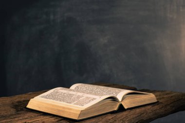 Kutsal İncil haç ve eski meşe ahşap masa üstündeki. Güzel koyu arka plan. Din kavramı