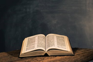 Kutsal İncil haç ve eski meşe ahşap masa üstündeki. Güzel koyu arka plan. Din kavramı