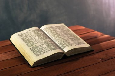 İncil'in üzerine kırmızı ahşap bir masa. Güzel arka plan. Din kavramı