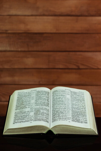 Bible and a crucifix on a black glass table. Beautiful background.Religion concept.