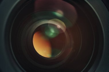 Siyah arka plan üzerinde cam sarı ve pembe ışık ile güzel kamera lensi.