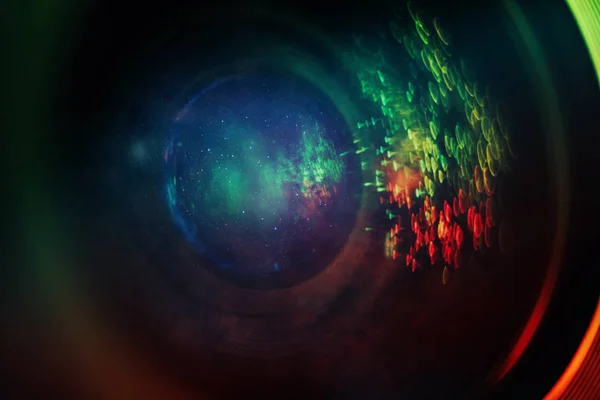 Beautiful abstract camera lens background multi colored glass reflection. Nebula dust in infinite space. Mixed media. Macro photography view.