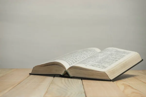 Biblia Abierta Sobre Una Vieja Mesa Madera Fondo Pared Blanco —  Fotos de Stock