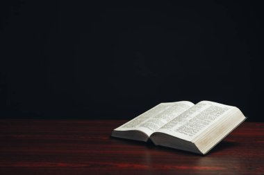 Kırmızı ahşap bir masada incili aç. Güzel siyah arkaplan.