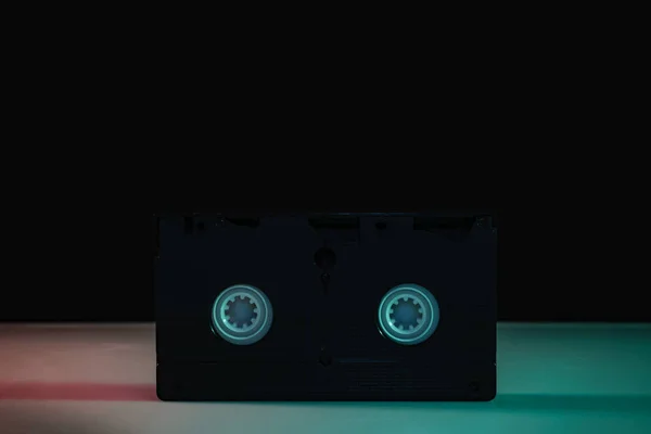 テーブルと夜の背景の色の光の中で美しいビデオカセット — ストック写真