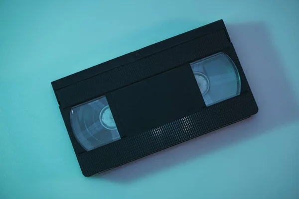 Beautiful video cassette in the color light on a table and night background. Top view.
