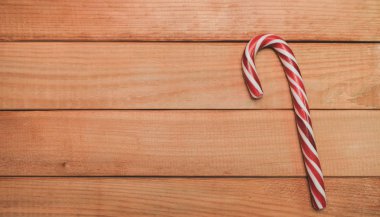 Güzel çizgili, sert baston şeker asası ahşap bir masa arkasında.