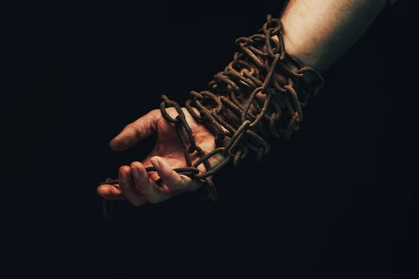 人間の手は黒い背景に隔離された鎖につながれている — ストック写真