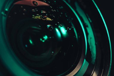 Düşen suyun güzel kamera lenslerini kapat, ışığı kapat. Tasarım için arkaplan modeli. Makro fotoğrafçılık görünümü
