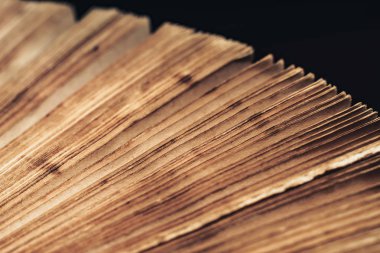 Siyah arka planda çekilen antik kitap çekimlerini kapat. Kitap kötü durumda..