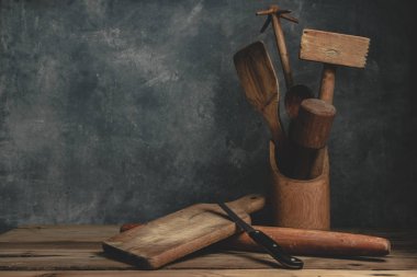 Meşe ağacından bir masa ve gri duvar arkaplan boncuğu üzerinde güzel, klasik mutfak aletleri..
