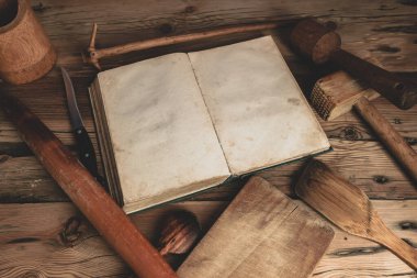 Meşe ağacından bir masa üzerinde mutfak gereçleri olan güzel bir klasik yemek kitabı..