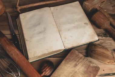 Meşe ağacından bir masa üzerinde mutfak gereçleri olan güzel bir klasik yemek kitabı..