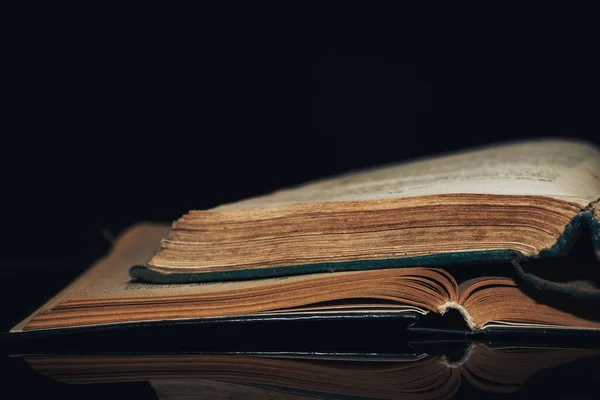 Beautiful ancient book pattern background for design. The book on a  black glass table  background.