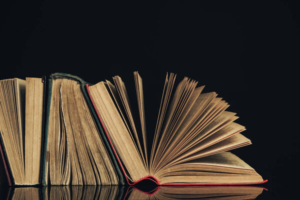 Beautiful ancient books. Pattern background for design. The book on a black glass table background.