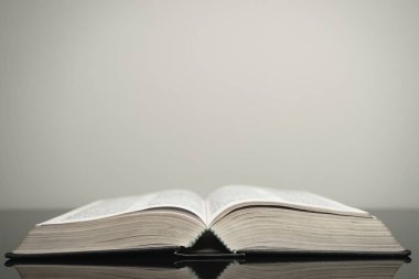 Cam sehpada ve beyaz arka planda kutsal kitabı aç. Din kavramı.