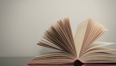 Gri ve cam masa arkaplanı üzerine açık güzel bir kitap. 