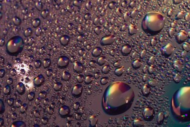 Holografik efektin çok renkli güzel su damlası. Tasarım için arkaplan modeli. Makro fotoğrafçılık görünümü.