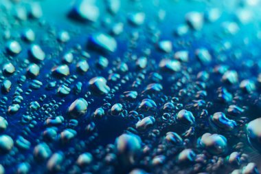 Holografik efektin güzel, soyut, mavi renkli, hafif su damlasını kapatın. Tasarım için arkaplan modeli. Makro fotoğrafçılık görünümü.