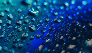 Holografik efektin güzel, soyut, mavi renkli, hafif su damlasını kapatın. Tasarım için arkaplan modeli. Makro fotoğrafçılık görünümü.