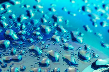 Holografik efektin güzel, soyut, mavi renkli, hafif su damlasını kapatın. Tasarım için arkaplan modeli. Makro fotoğrafçılık görünümü.