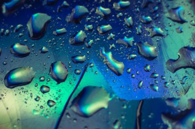 Güzel soyutlama, holografik efektin çok renkli hafif su damlası. Tasarım için arkaplan modeli. Makro fotoğrafçılık görünümü.