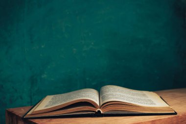 Güzel, antika bir kitap. Tasarım için model arka planı. Siyah cam masa arkaplanındaki kitap..