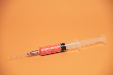 Sarı arka planda güzel bir şırınga. Coronavirus konsepti, kendinizi koruyun..