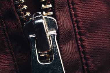 Kırmızı kumaş arka plandaki fermuarı dikişle kapat. Makro fotoğrafçılık arka plan materyal görünümü.