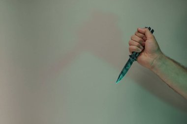 Renkli ışıkta eski kelebek bıçağıyla el ele tutuşmak. Neon ışıkta çok güzel ve eski bir minimal. Minimalizm retro tarzı konsept. Tasarım için arkaplan deseni.