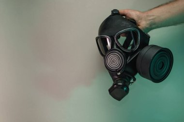 Renkli ışıkta eski siyah gaz maskesini tut. Neon ışıkta çok güzel ve eski bir minimal. Minimalizm retro tarzı konsept. Tasarım için arkaplan deseni.