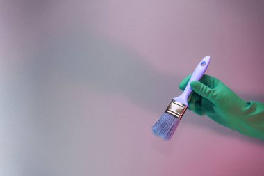 Beutiful Hand holding paint brush in the in neon light. Minimalism retro style concept. Background pattern for design.	