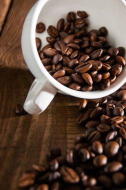 Yarım fincan kahve çekirdekleri close-up. Bir bölümü dağınık