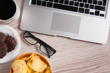 Laptop ve ahşap masa üzerindeki fişlere kase. Kötü alışkanlıkları kavramı