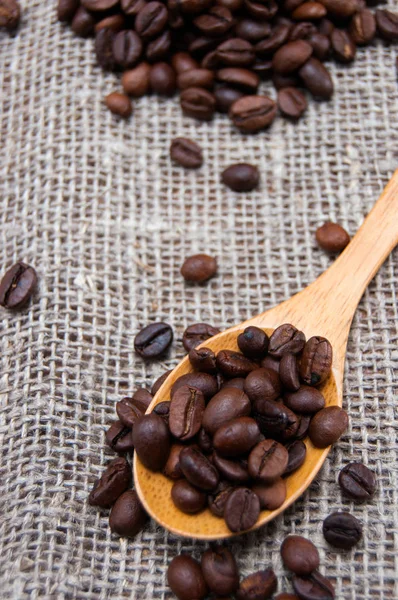 Cuchara de madera con granos de café — Foto de Stock