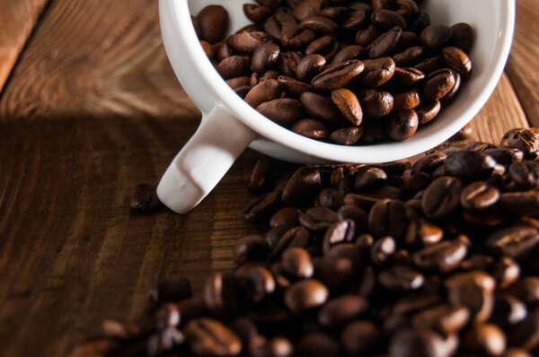 Close-up of half a cup of coffee beans. A part is scattered