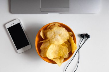 Dizüstü bilgisayar, buruşuk kağıt ve ahşap masa üzerindeki fişlere kase çalışma alanı. Kötü alışkanlıkları kavramı