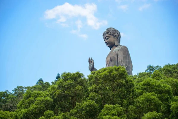 Big Buddha ile bulutlar güneş gün güzel mavi gökyüzü arka plan üzerinde yeşil ormandaki Hong Kong'da. Özgürlük, hafiflik hissi, huzur, uyum, ışık, sevgi. Lantau Island.