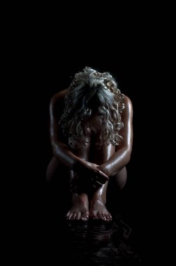 Yere diz sarılma karanlıkta oturmak güzel seksi çıplak sapıkça sarışın erkek. Başını dizlerinin için eğilerek. Yerdeki sudan yansıtan ışık, onun vücut parlar.