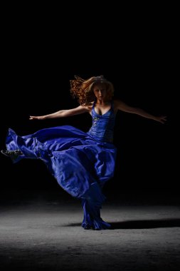 Karanlıkta, dans eden kız pirouettes gerçekleştirir