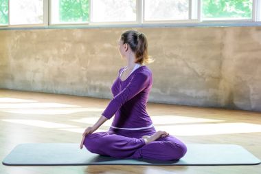 Güzel atletik genç kadın yapmak yoga pratik, Lotus pozisyonu Padmasana büküm, esneme, pilates zamanla mükemmel kız. Tam geri çevirmek