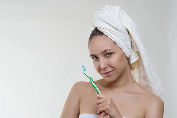 Güzel taze cilt, sağlıklı bir görünüm ve beyaz arka plan üzerinde bir diş fırçası ile poz bir havlu harika gülümseme mutlu güzel genç kadın. Spa sağlık sağlık modeli fotoğraf çekim
