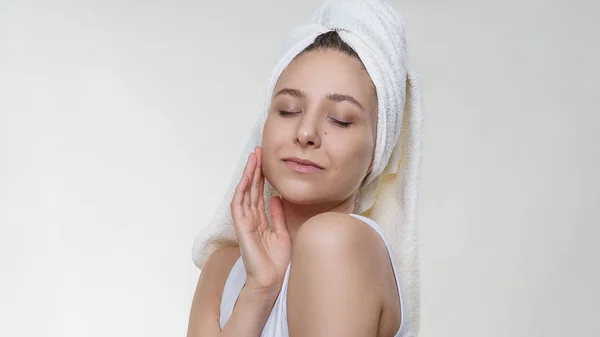 Beyaz arka plan üzerinde mutlu gülümseme ile poz bir havlu hassasiyet mükemmel temiz cilt ile oldukça inanılmaz bir kadın. Spa sağlık portre fotoğrafçılığı