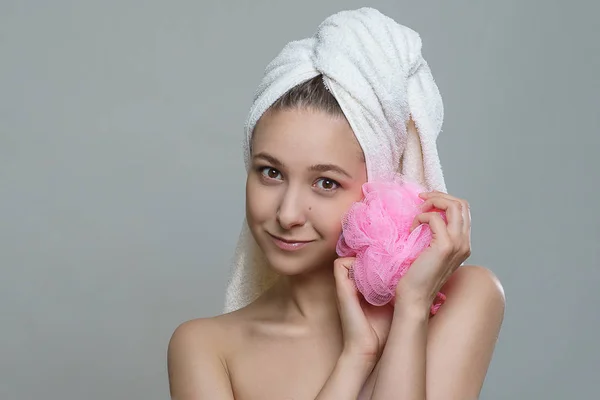 Güzel taze cilt, sağlıklı bir görünüm ve beyaz arka plan üzerine bir sünger ile poz bir havlu harika gülümseme mutlu sevimli genç kız. Spa sağlık sağlık modeli fotoğraf çekim